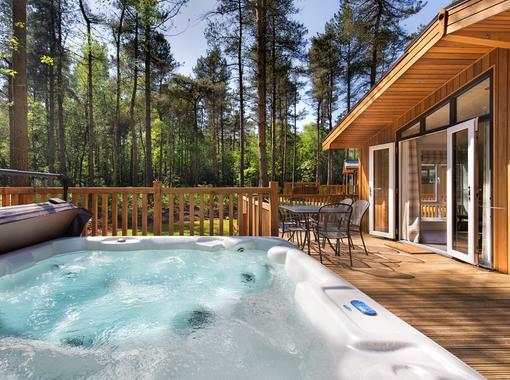 outdoor hot tub on lodge verandah surrounded by pine trees
