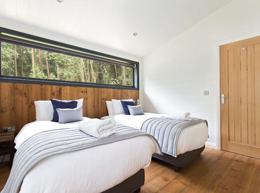 Twin bedroom with crisp white bedding with large window 