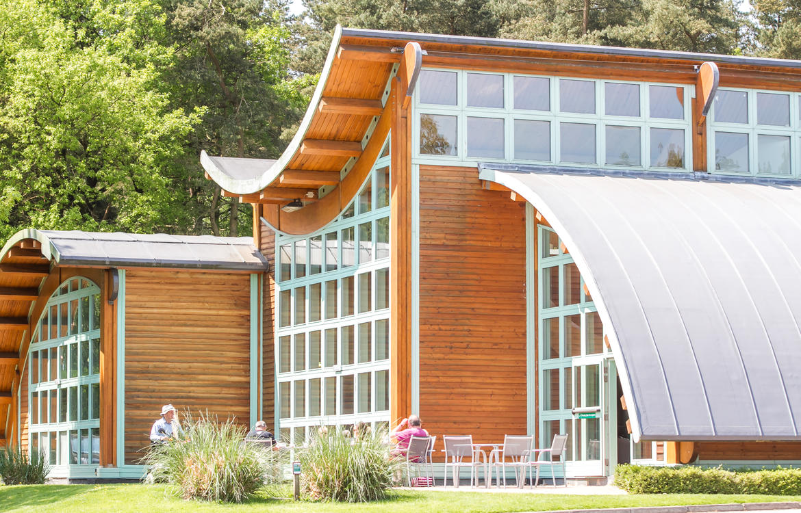 Exterior of Evolution showing seating area outside and unique shape of the arched roof