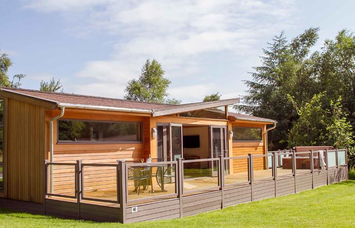 Modern lodge with large decking and hot tub