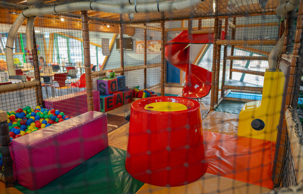 Young boy having fun with the ball machine in the toddler area