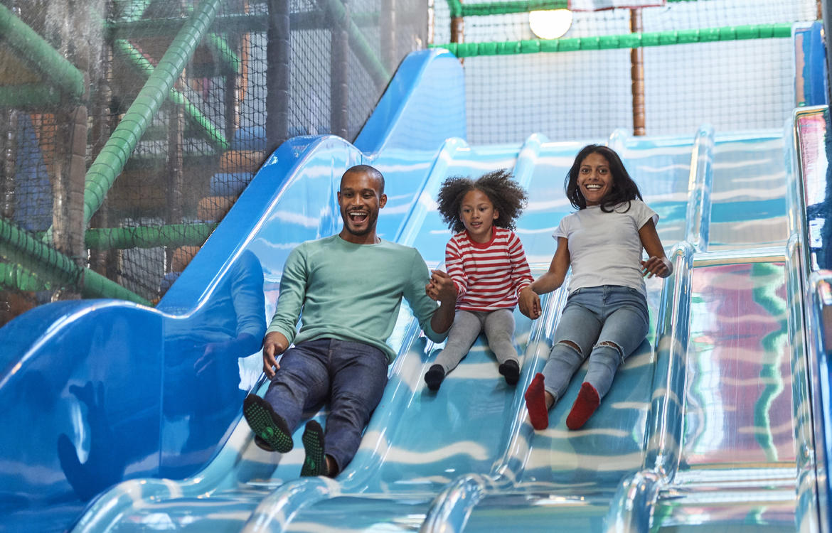 Parents & Child coming down a blue slide