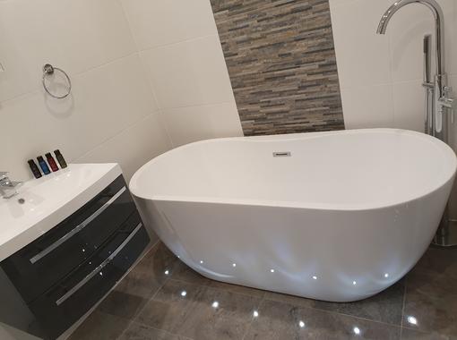 Large modern freestanding bath, surrounded by floor led lightinglighto