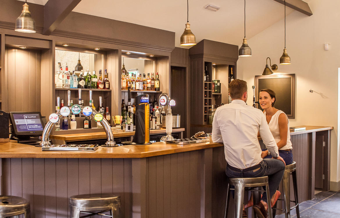 A couple sat at the bar enjoying a drink