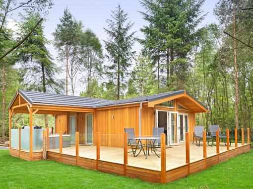 Outdoor hot tub under wooden canopy looking out on to surrounding woodland