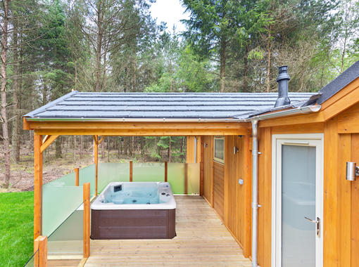 Bubbling outdoor hot tub under wooden canopy