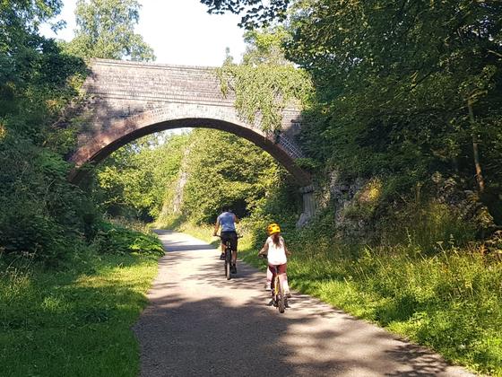 Adult and child cycling along the monsal trail