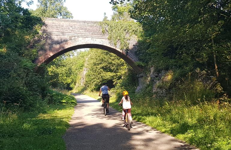 Adult and child cycling along the monsal trail