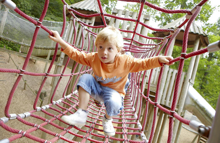 Child walking through rope tunnel