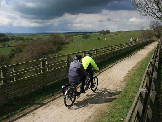Couple cycling along a trail with picturesque views