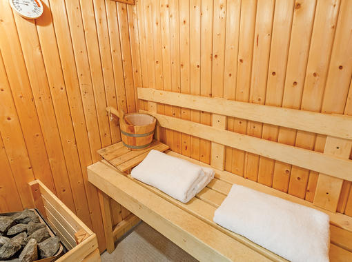 Sauna with seating area for two people and towels 