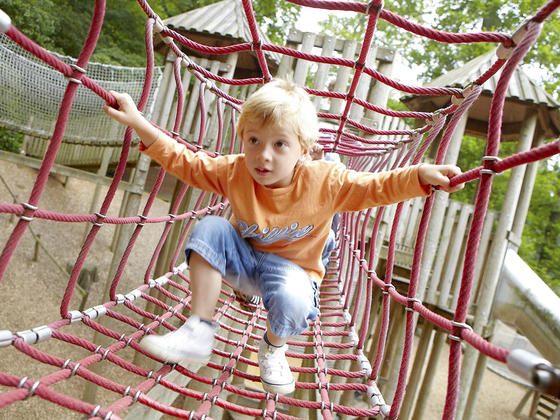 Child walking through rope tunnel at Chatsworth playground